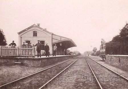 Station Driebergen-1895-001.jpg - Het Stationsgebouw werd in 1864 gebouwd, gedeeltelijk op de oude fundering van het gebouw uit 1844. In 1899 is het verbouwd en kwam er een verdieping op. Later in 1894 kwam over het spoor een luchtbrug en in 1895 werd de brug overdekt. Gezicht vanaf de overweg Zeist-Driebergen. Opname van 1865.